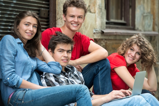 Smiling young people using laptop