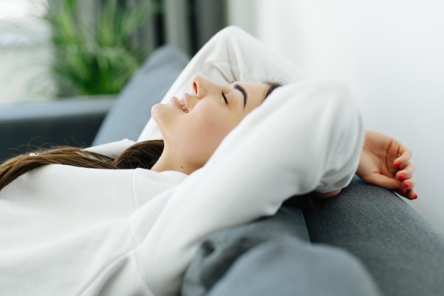 Smiling young pretty woman lying on couch