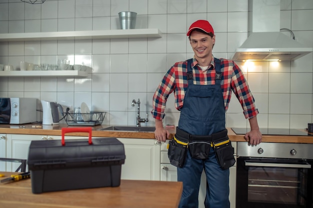 Smiling young repair technician standing in a customer apartment