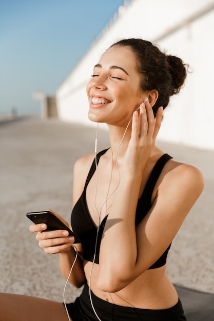 Photo smiling young sportswoman at the seaside