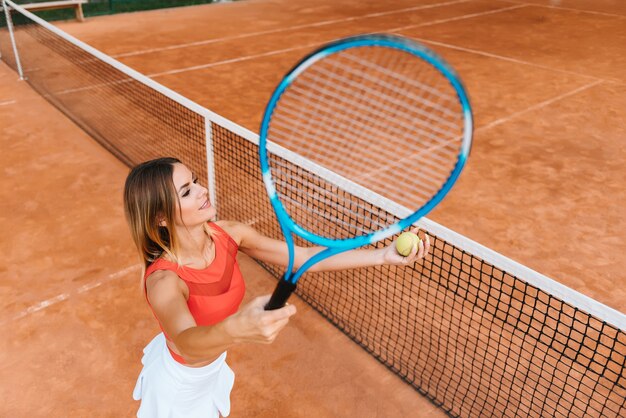 Smiling young sporty girl playing tennis