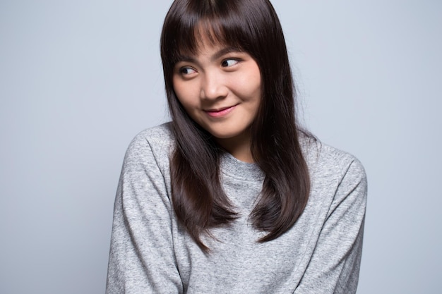 Smiling young woman against gray background