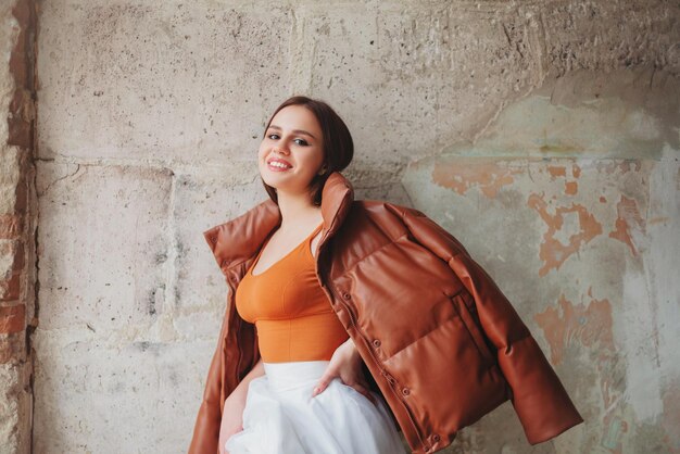 Photo smiling young woman against wall