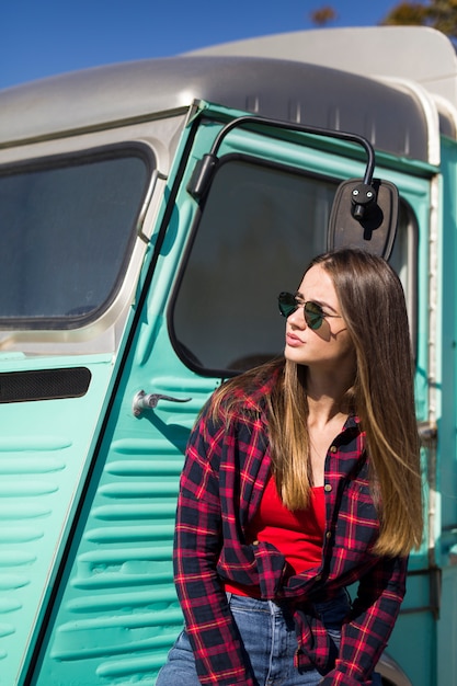 Smiling young woman by the vintage minivan