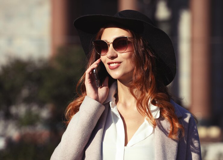 Photo smiling young woman calling and talking on smartphone in the aut