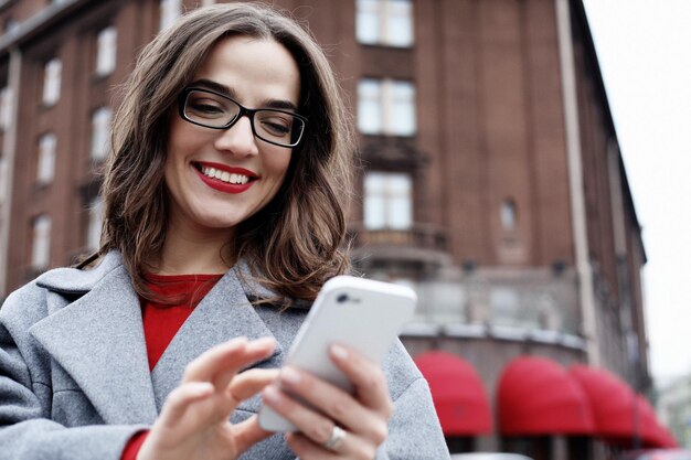 Smiling young woman calling and talking on smartphone