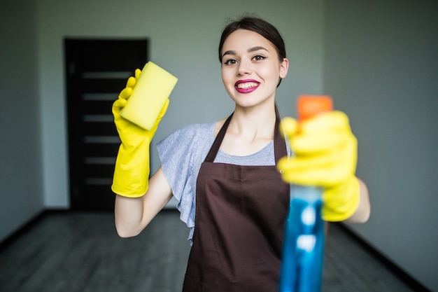 Smiling young woman clean the window with rag