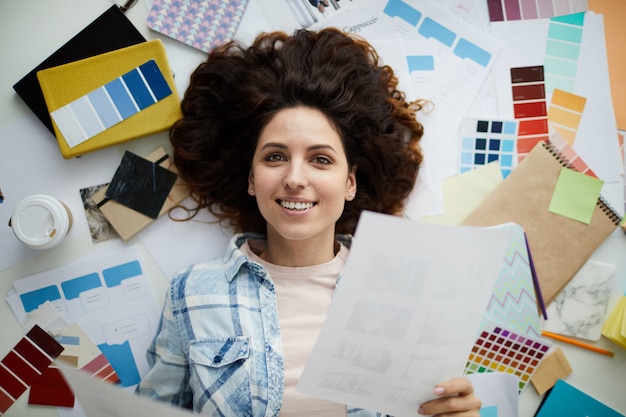 Giovane donna sorridente nel disordine creativo