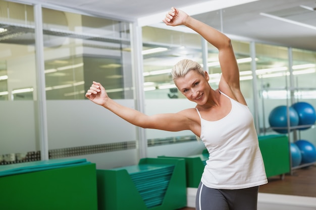 Smiling young woman doing power fitness exercise