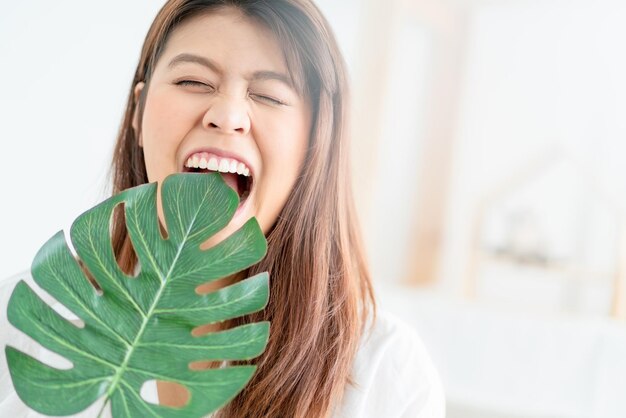 사진 잎을 먹는 미소 짓는 젊은 여성