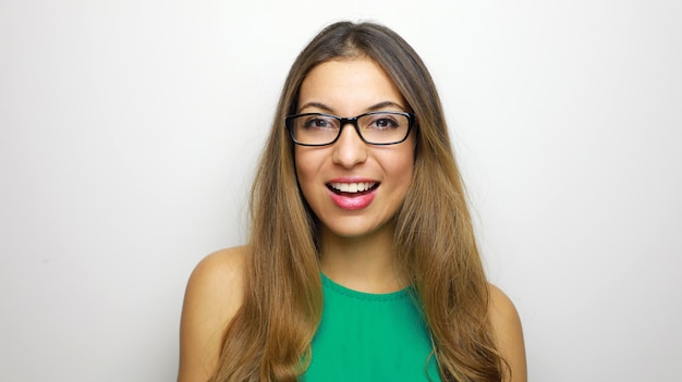 Smiling young woman in eyeglasses posing