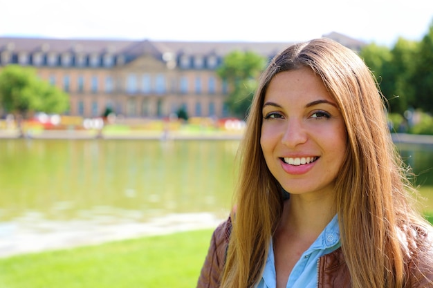 Smiling young woman in front of Neues Schloss, Stuttgart, Germany