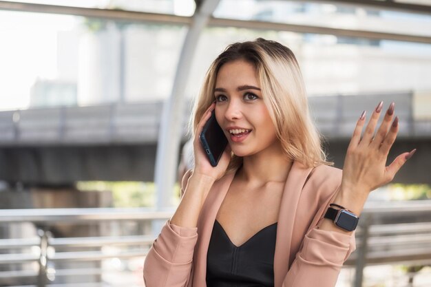 Smiling young woman gesturing while talking on mobile phone