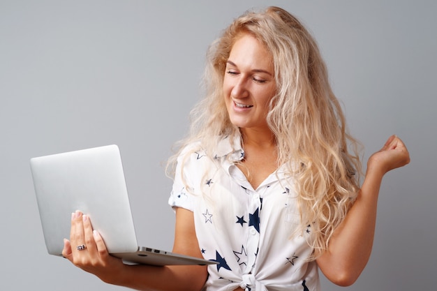 Smiling young woman holding laptop 