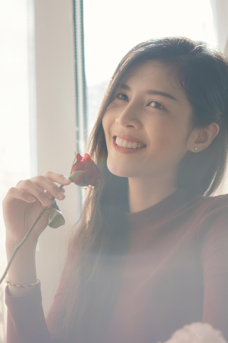 Photo 一位微笑着的年轻女人抱着一朵<unk>,看着家里