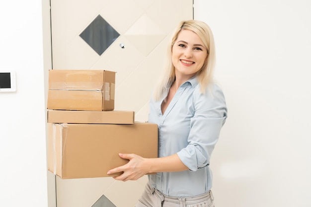 Smiling young woman at home received a postal parcel, online shopping and delivery concept