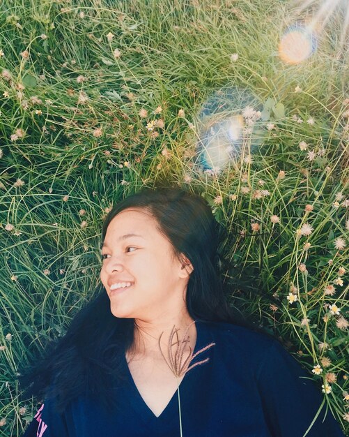 Photo smiling young woman lying on field