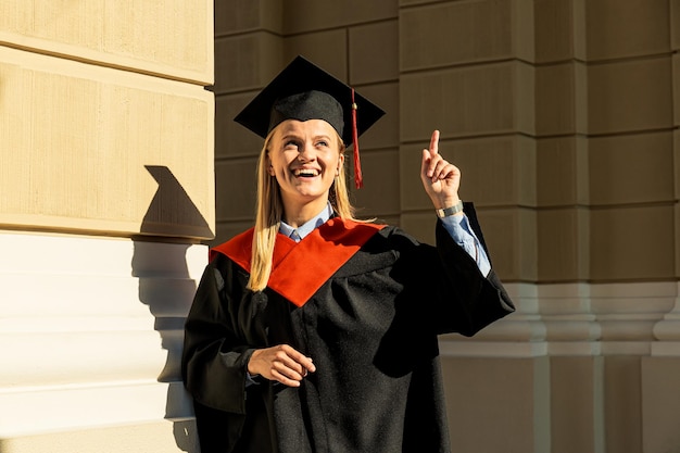 Smiling young woman in mantle and hat outdoors