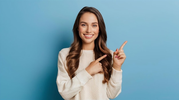 Smiling young woman pointing at copy space over blue background