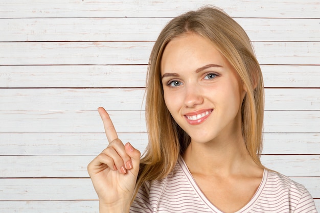 Smiling young woman pointing