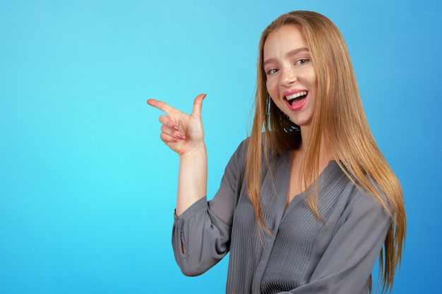 Smiling young woman pointing