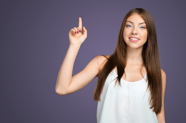 Smiling young woman pointing