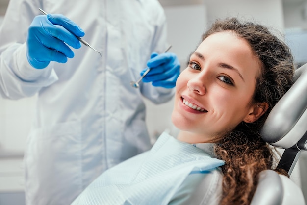 Smiling young woman receiving dental checkup close up view Healthcare and medicine concept