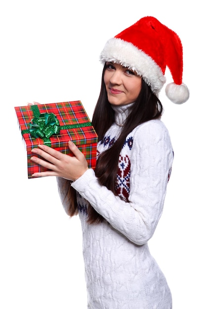 贈り物と白い背景で赤いクリスマス帽子の笑顔の若い女性