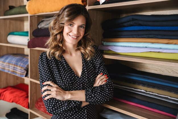 Sorridente giovane donna sarta che lavora in officina, scegliendo tessile