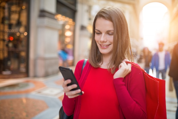 Acquisto sorridente della giovane donna a milano, italia