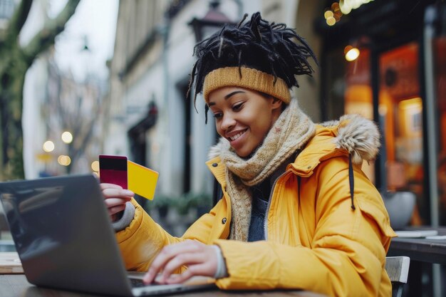 Foto giovane donna sorridente che compra online con carta di credito e portatile all'aperto