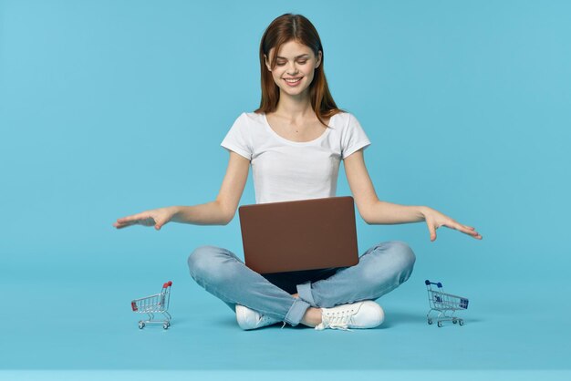 Smiling young woman sitting against blue background