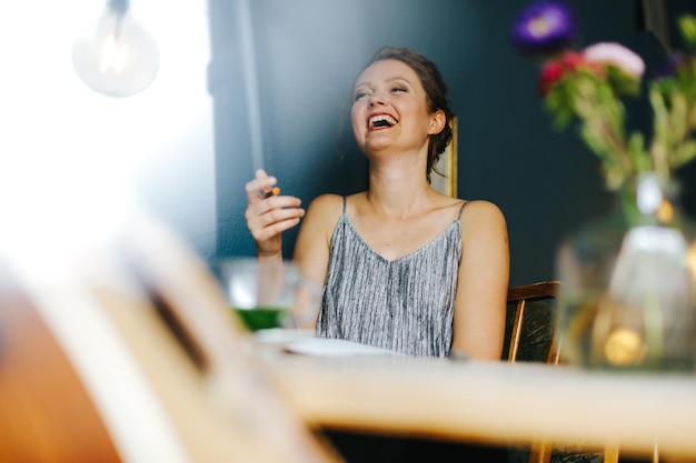 カフェに座っている笑顔の若い女性