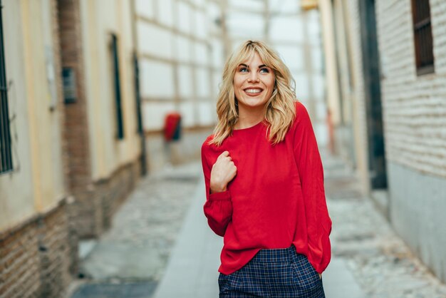 Foto una giovane donna sorridente in piedi nel vicolo