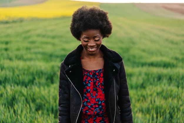 Smiling young woman standing on field