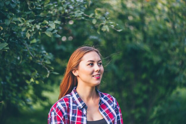 Smiling young woman standing in the park