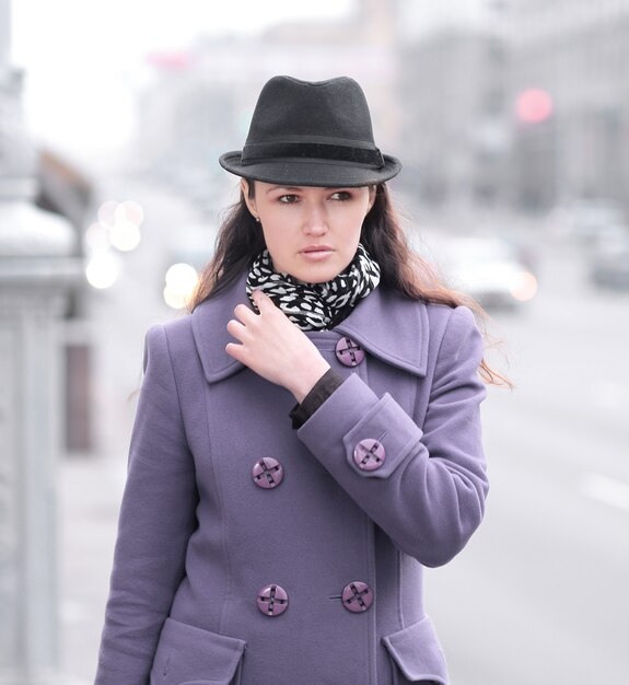 Smiling young woman standing on street in city.