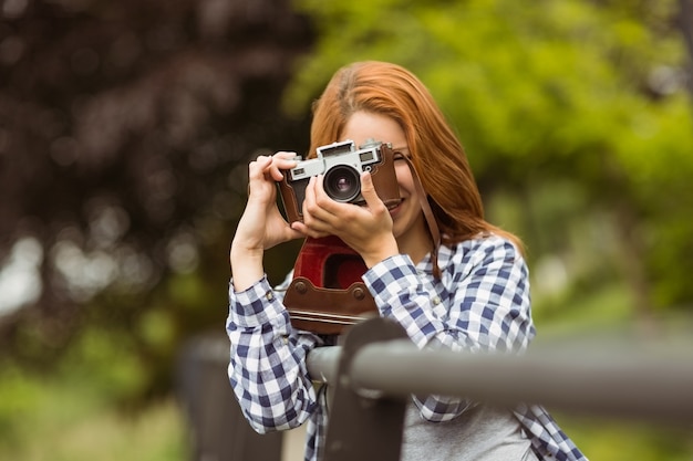 カメラで写真を撮っている若い女性に笑顔