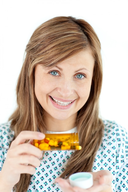 Smiling young woman taking pills 