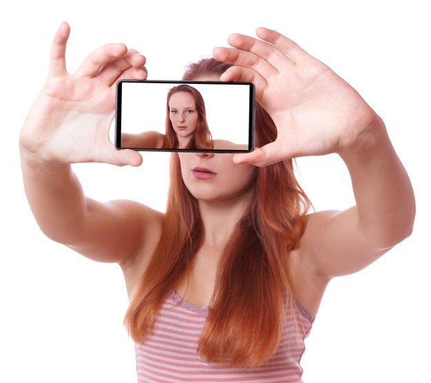 Photo smiling young woman taking selfie from smart phone against white background