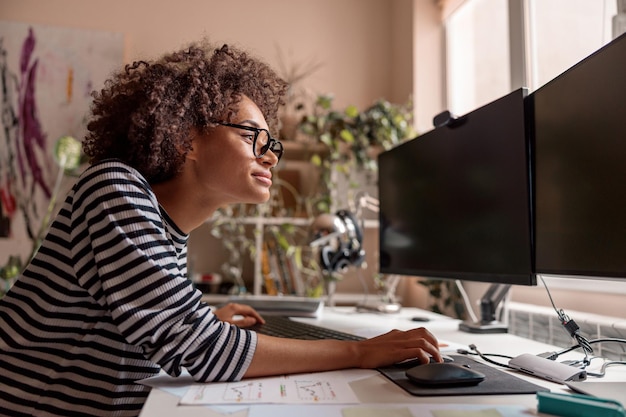 Smiling young woman using computer at home