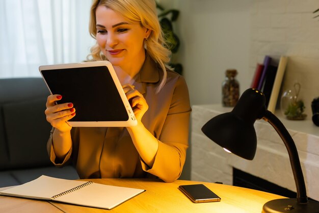 Smiling young woman using a digital tablet hands close up