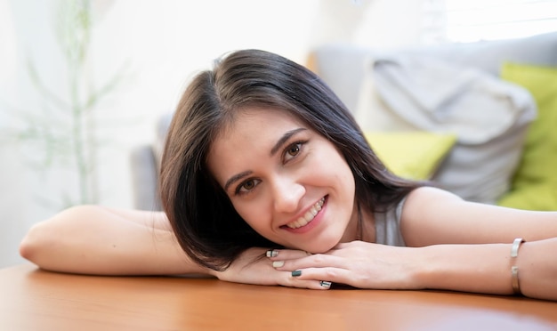 Giovane donna sorridente che per mezzo del computer portatile contro l'albero di natale.