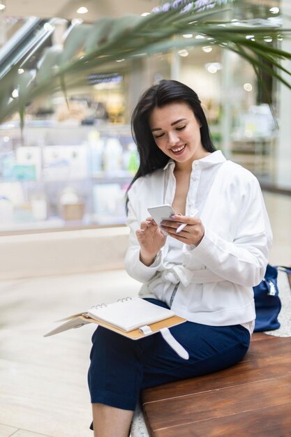 Foto giovane donna sorridente che usa il cellulare