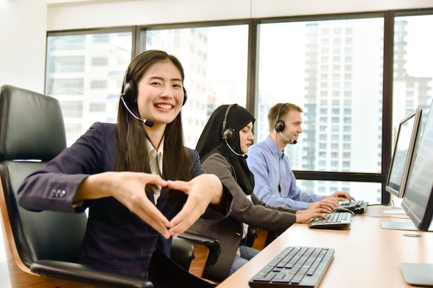 Smiling young woman using phone while sitting on table