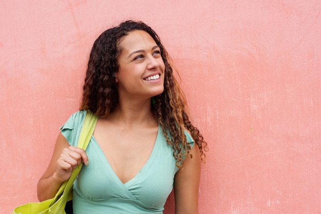 Smiling young woman with curly hair and bag 