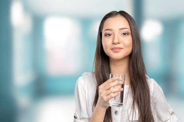 Giovane donna sorridente con bicchiere d'acqua