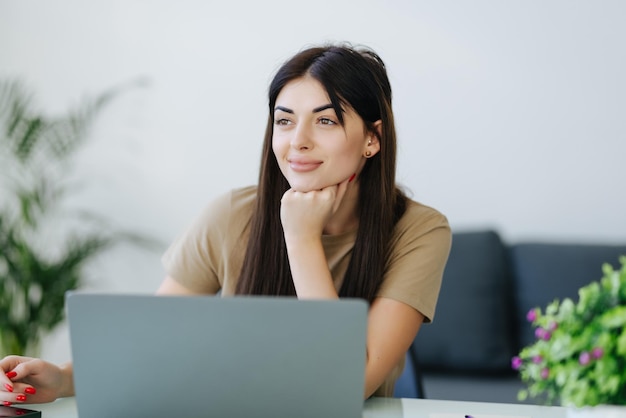 Smiling young woman with laptop in home office