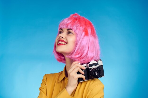 Smiling young woman with smart phone against blue background