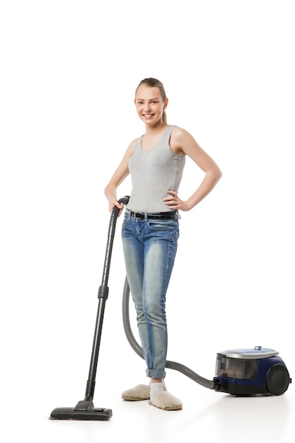 Smiling young woman with vacuum-cleaner, housewife, isolated on white